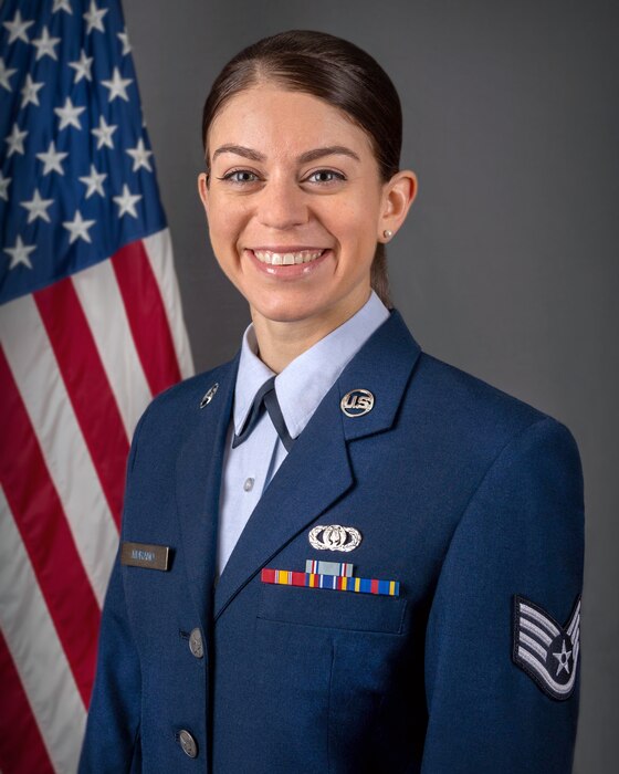 An official headshot of SSgt Andrea Murano in front of the American flag. She is wearing the blue service dress uniform.