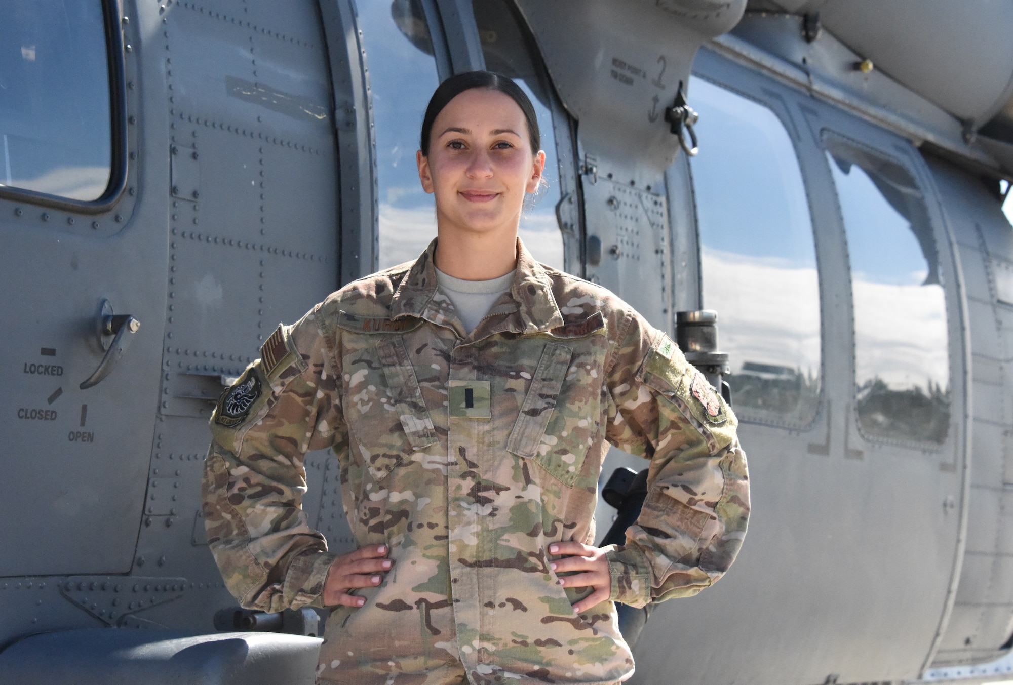 An officer stands in front of a helicopter.