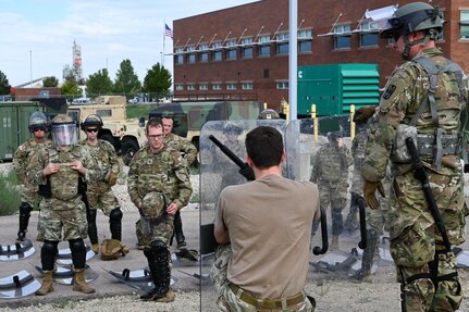 an instructor shows a crowd of soldiers proper technique when blocking thrown objects when using a riot shield.