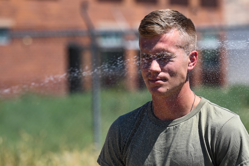 A soldier with eyes closed is sprayed with OC spray.