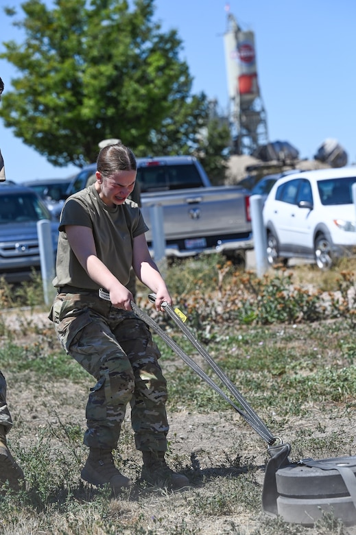 A female soldier pulls a weighted sled after being sprayed with OC spray.