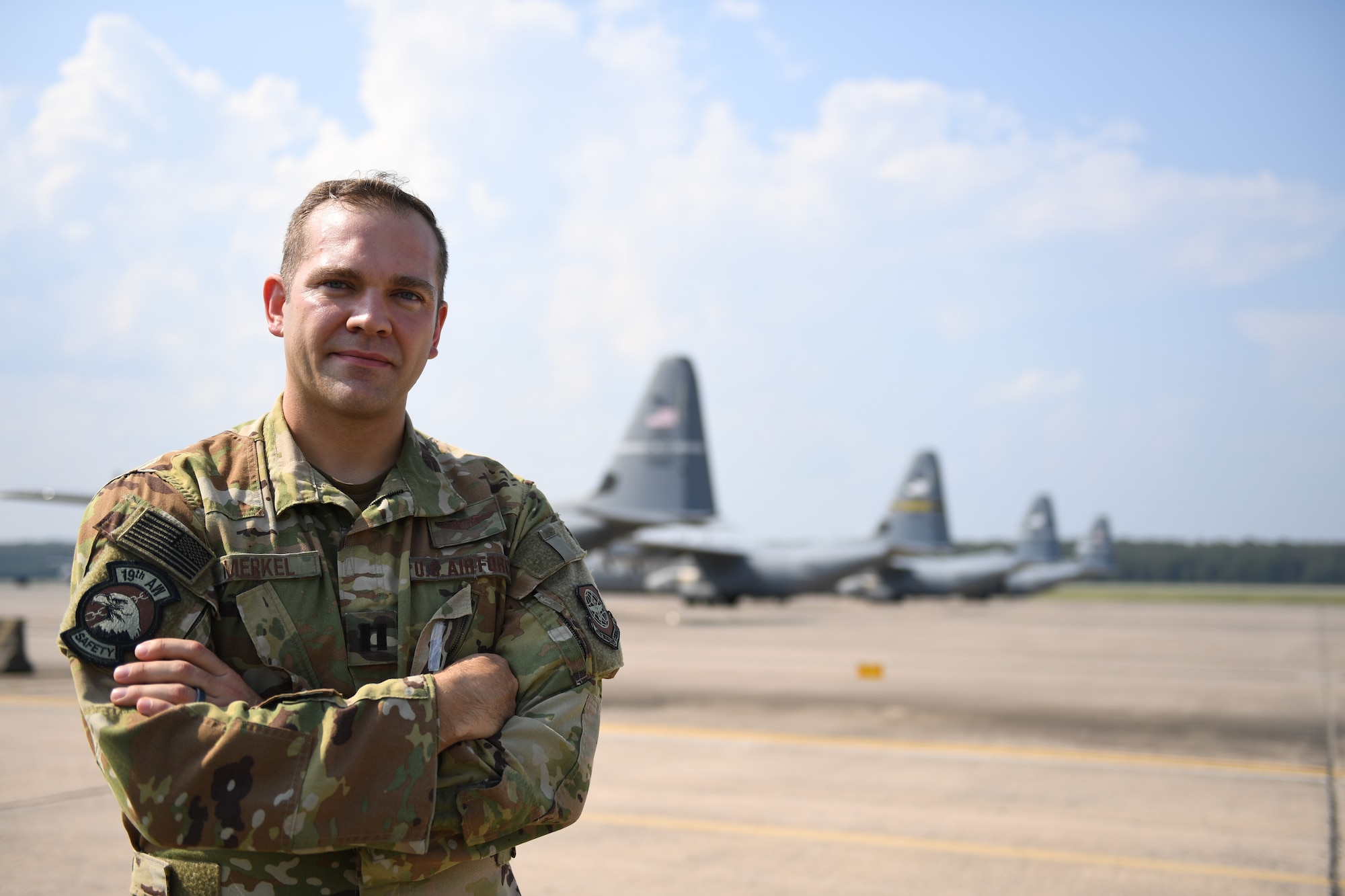 An Air Force Officer poses for a photo on a flight line.