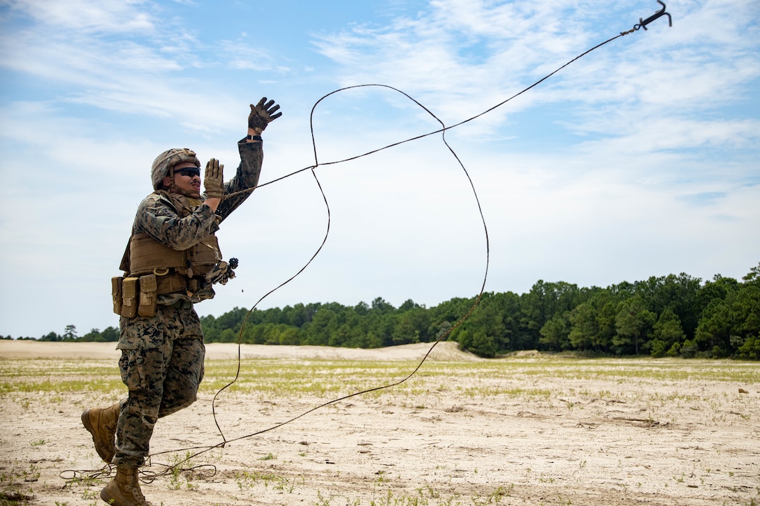 U.S. Marine Corps Cpl. Jhonny Batistaparra, a combat engineer with Combat Logistics Battalion 22, Combat Logistics Regiment 2, 2nd Marine Logistics Group, throws a hook during a live demolition range on Camp Lejeune, North Carolina, Aug. 24, 2022. CLB-22’s Marine Corps Combat Readiness Evaluation is the battalion's final evaluation to demonstrate combat readiness through proficiency in core mission essential tasks before they begin a change of operational control to the 26th Marine Expeditionary Unit.