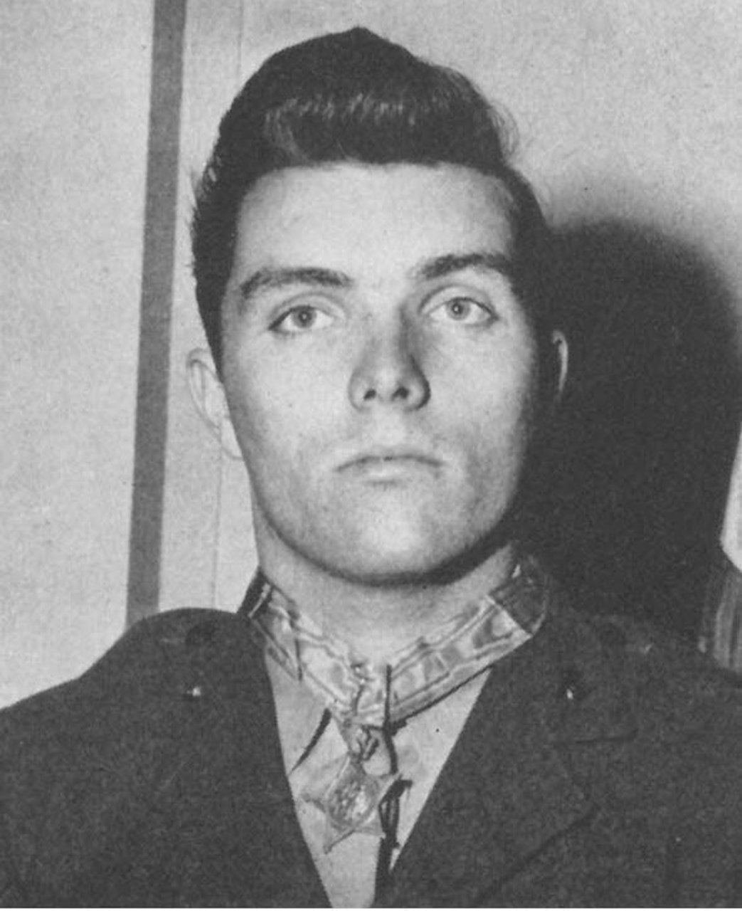 A man wearing a medal around his neck poses for a photo.