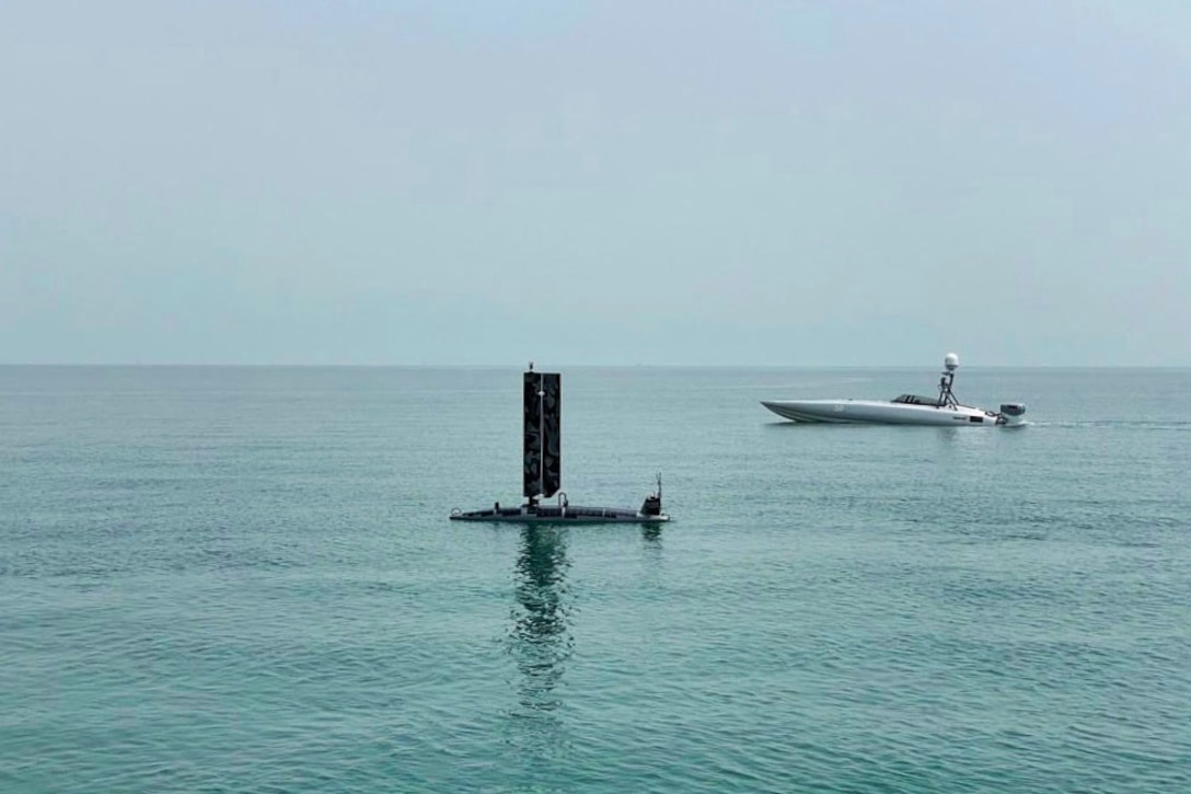 A Triton unmanned surface vessel, left, and a Devil Ray T-38 USV operate in the Red Sea.