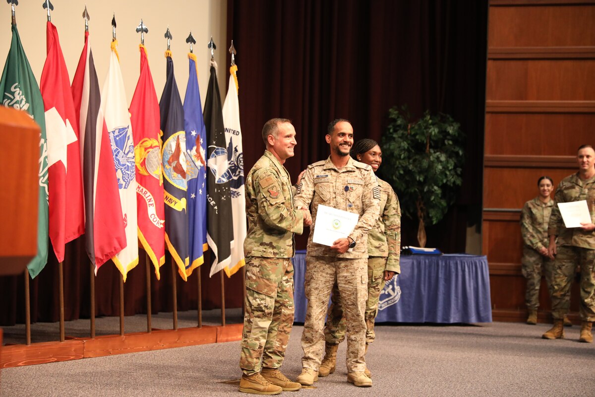 Chief Master Sgt. Daniel Hoglund, Air Force Senior Noncommissioned Academy commandant, presents a graduation certificate to Royal Saudi Air Force Senior Master Sgt. Hassan Alkhaldim at the SNCOA Class 22F graduation ceremony, Aug. 10, 2022.   The RSAF’s top senior enlisted member, Chief Master Sgt. Mohammed Saud Alosaimi, and the commandant of the RSAF Noncommissioned Officer Leadership School, Chief Master Sgt. Sameer Awadh Alotaibi attended the graduation. While here, the RSAF enlisted leaders discussed the ongoing and expanding partnership between the SNCOA and RSAF in the professional military development of RSAF enlisted members.