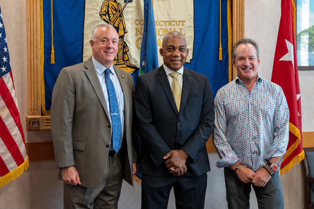 Three men pose for a photo