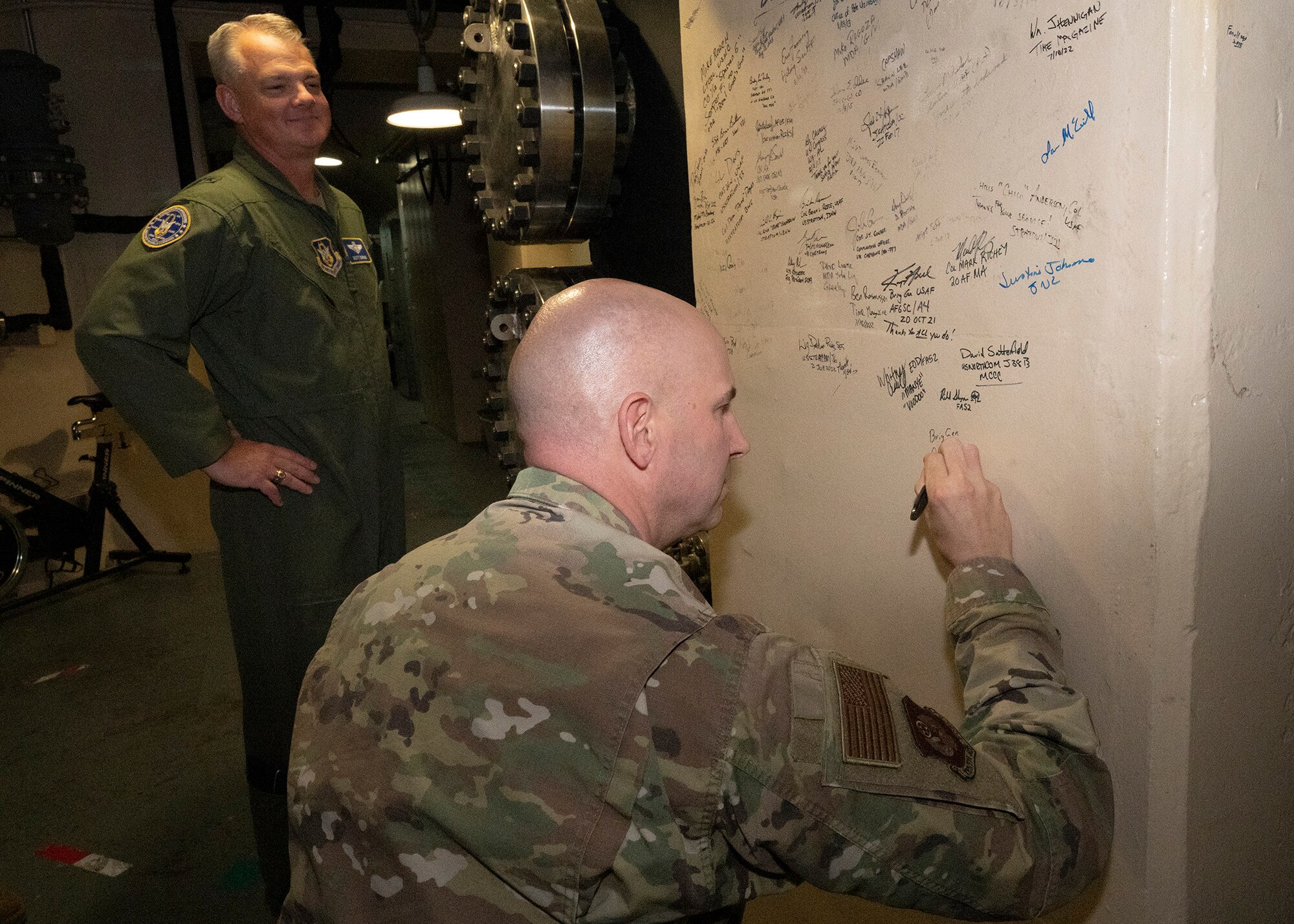 BG Sniegowski signs his name on a wall