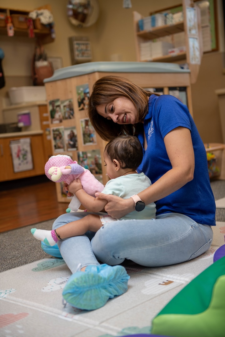 female teacher holds a toddler