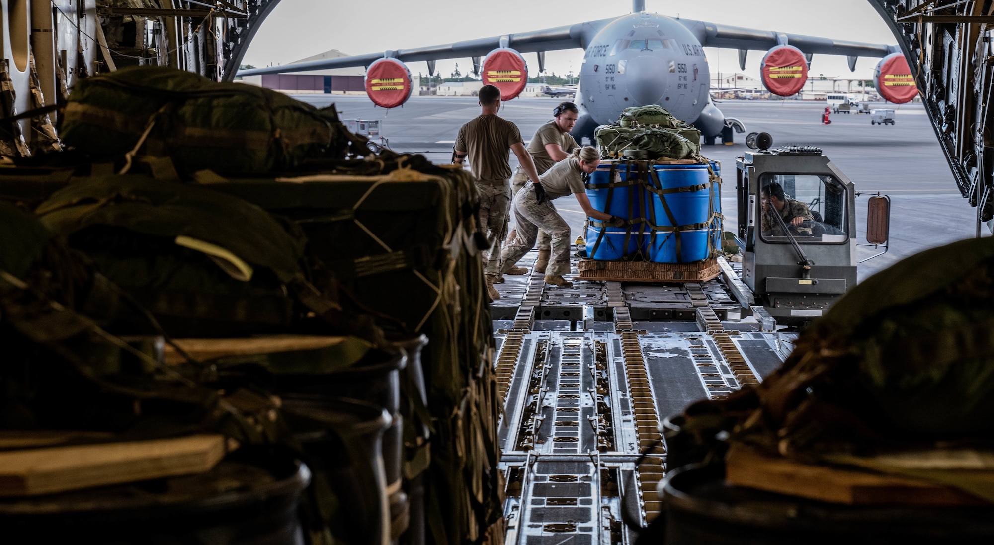 Airmen assigned to the 535th Airlift Squadron and the 647th Logistics Readiness Squadron load  container delivery system bundles onto a C-17 Globemaster III in support of an air drop exercise  at Joint Base Pearl Harbor-Hickam, Hawaii, Aug. 24, 2022. Airdrop exercises provide Airmen with real world training opportunities to advance the 15th Wing’s mission of rapid global mobility. (U.S. Air Force photo by Senior Airman Makensie Cooper)