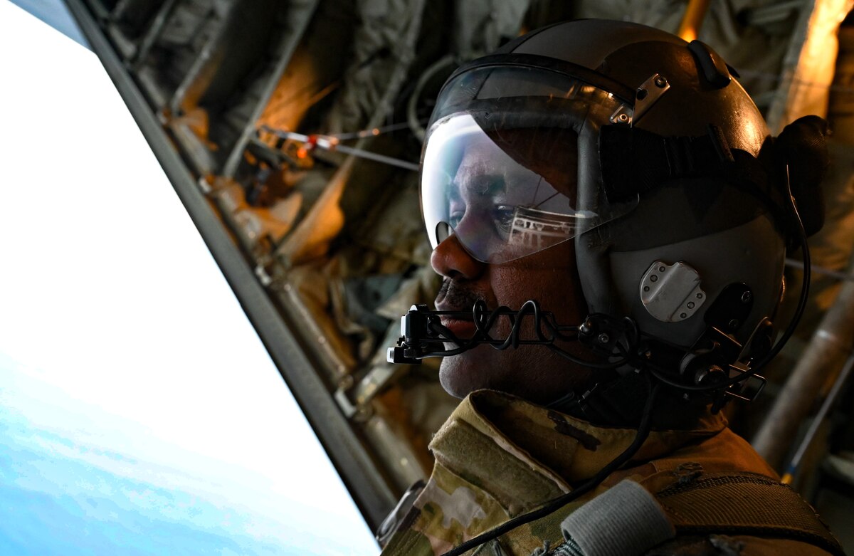 Photo of U.S. Air Force Master Sgt. Gary Bryant, 815th Airlift Squadron loadmaster, looking out the back of a C-130J Super Hercules over Guatemala, prior to static line operations as part of Resolute Sentinel 22, June 15, 2022.