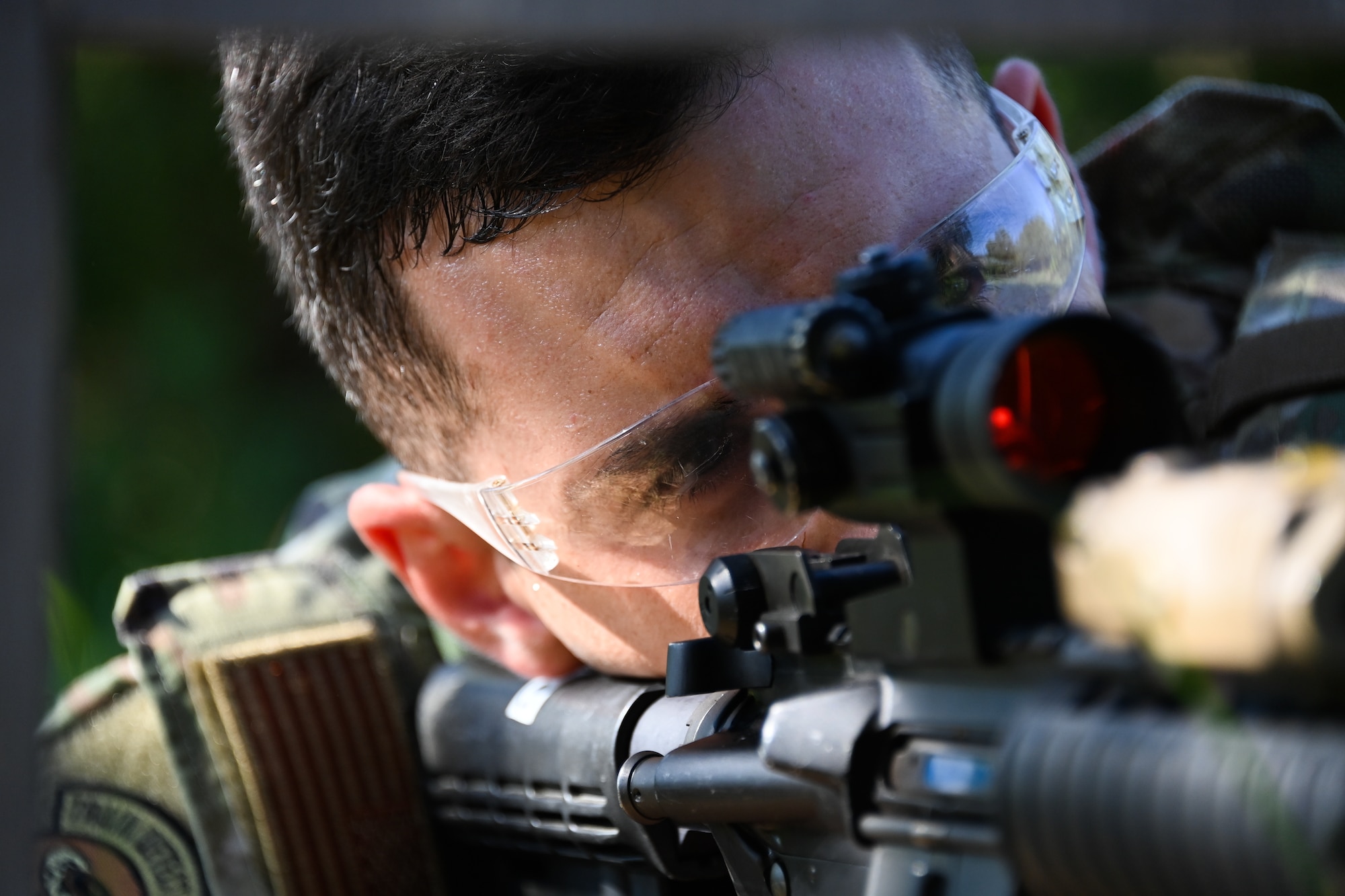 Tech. Sgt. Reece Dinofsky, 316th Security Support Squadron assistant NCO in charge of training, aims an M4 Carbine toward a target during a weapons proficiency training exercise at Joint Base Andrews, Md., Aug. 23, 2022. Dinofsky acted as a mentor to three Airmen throughout the “shoot, move, communicate” exercise and created simulated events to enhance their training. (U.S. Air Force photo by Airman 1st Class Isabelle Churchill)