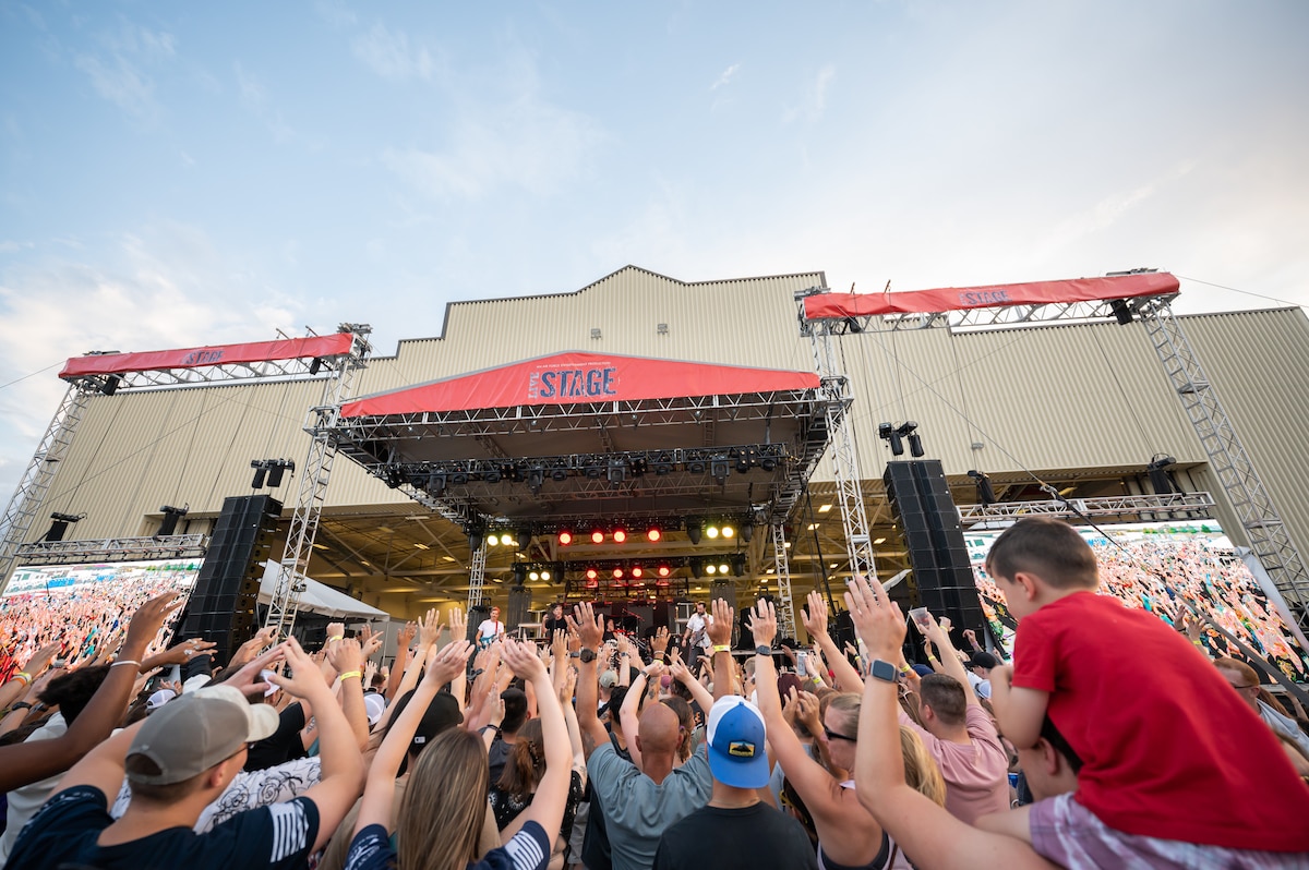 Audience members put their hands in the air during a song