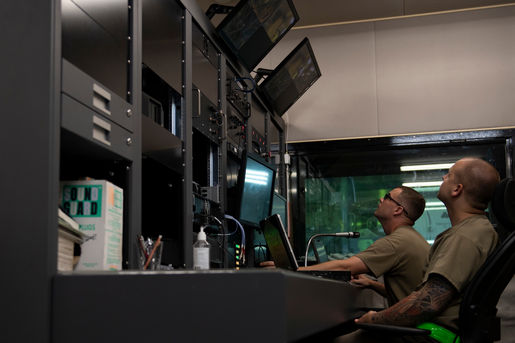 U.S. Air Force Staff Sgt. Dustin Chapman and Staff Sgt. Colby Barkdull Straw, 18th Component Maintenance Squadron test cell craftsmen, monitor engine run operations from the control booth at Kadena Air Base, Japan, Aug. 25, 2022. The operators inside the control booth monitor parameters such as oil pressure, exhaust temperatures, engine speed and fuel flow during the engine run. (U.S. Air Force photo by Senior Airman Jessi Roth)