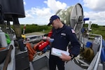 Petty Officer 3rd Class Joshua Smith, a marine inspector from Coast Guard Sector Anchorage’s Marine Safety Task Force (MSTF), inspects flares during a dockside commercial fishing vessel safety exam in Naknek, Alaska, June 15, 2022. MSTF members conducted exams throughout the Bristol Bay region June 13 - 24 focused on safety equipment such as flares, navigational signals, fire extinguishers, and the serviceability of immersion suits. Each vessel that passed a dockside exam earned a decal. U. S. Coast Guard photo by Petty Officer 2nd Class Melissa E. F. McKenzie.