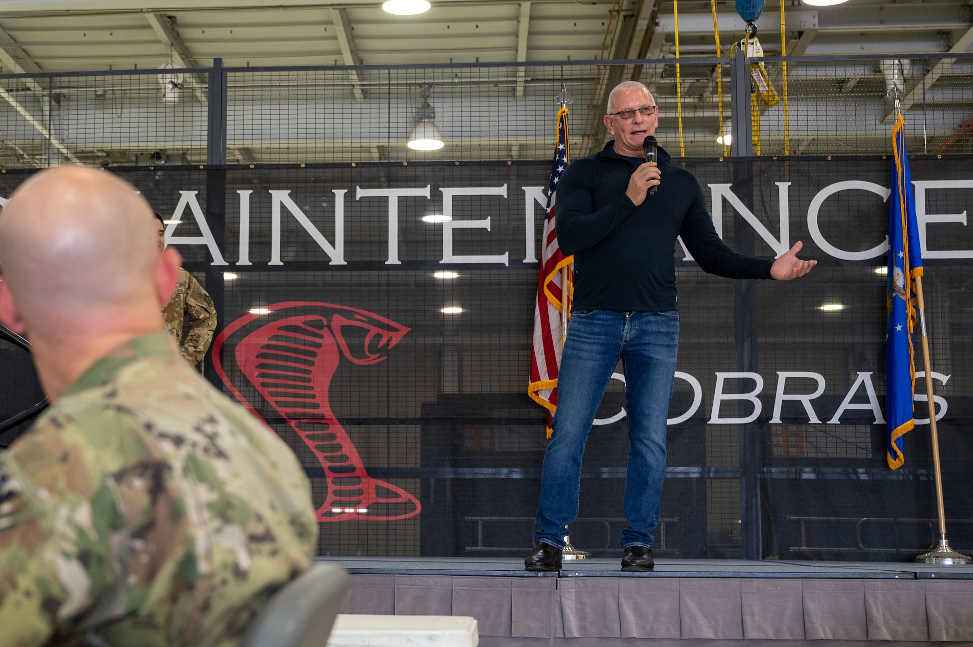 Robert Irvine, celebrity chef and talk show host, addresses Team Dover Airmen during the Meet, Greet, Eat with Chef Robert Irvine event on Dover Air Force Base, Delaware, Aug. 25, 2022. More than 75 Airmen attended the event which included a photo opportunity with Irvine and a catered lunch. (U.S. Air Force photo by Senior Airman Cydney Lee)