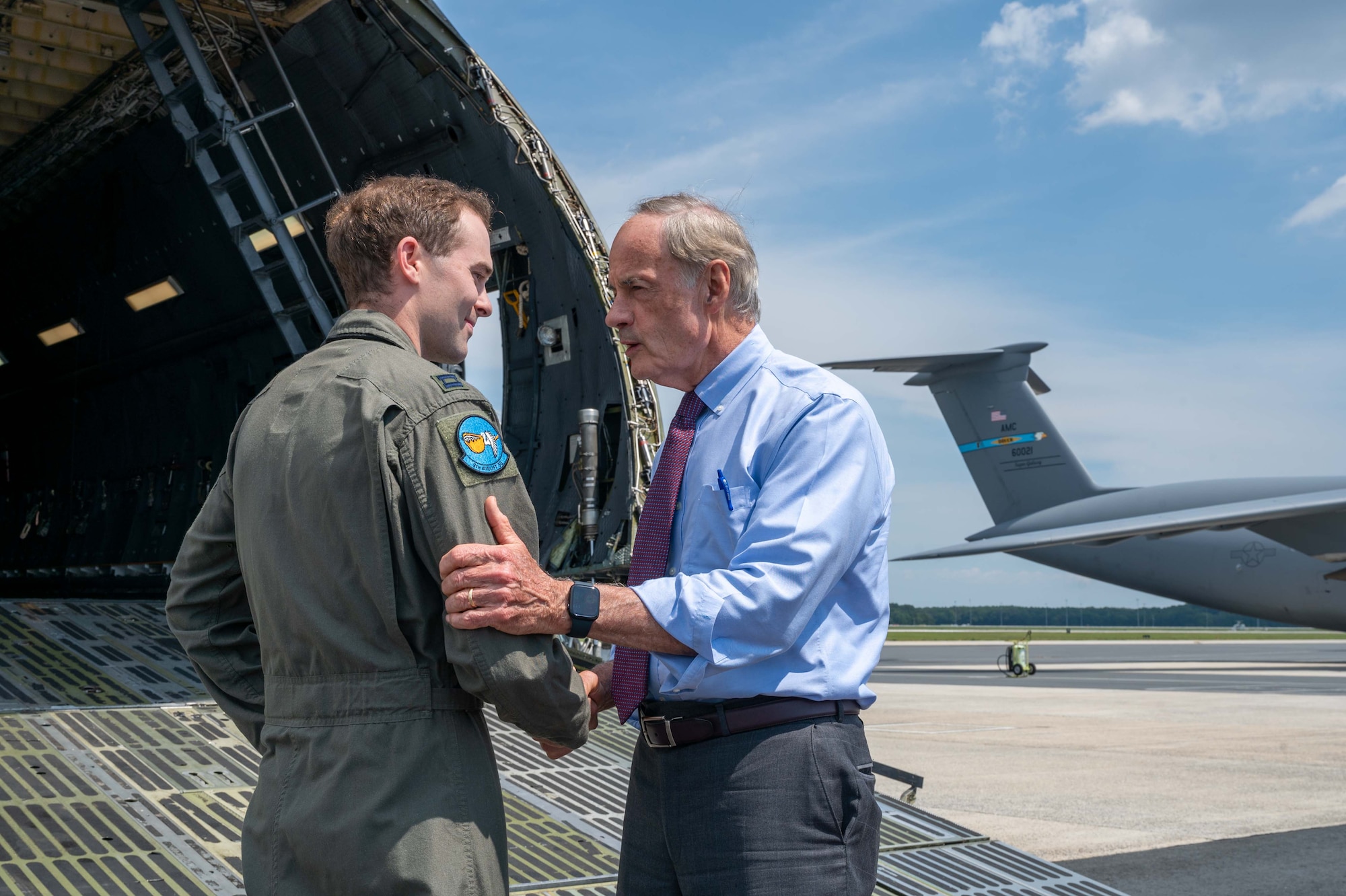 From the left, Capt. Scott Rider, 9th Airlift Squadron pilot, greets Sen. Tom Carper at Dover Air Force Base, Delaware, Aug. 25, 2022. During his visit, Carper engaged with Airmen, toured a C-5M Super Galaxy and discussed the airmen’s role in security assistance missions in support of U.S. partners and allies. (U.S. Air Force photo by Senior Airman Faith Barron)