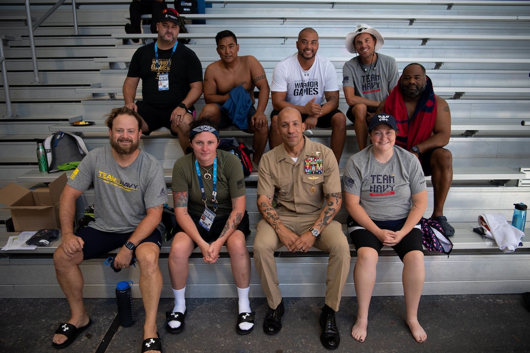 CENTCOM’s Senior Enlisted Leader, Fleet Master Chief Derrick "Wally" Walters, poses for a group photo with team Navy swimmers during the 2022 Department of Defense Warrior Games at the ESPN Wide World of Sports Complex in Orlando, Florida, Aug. 25, 2022. At the games, service members and veterans from across the DoD compete in adaptive sports alongside armed forces competitors from Canada and Ukraine. (Photo by U.S. Marine Corps Gunnery Sgt. Eric L. Alabiso II)