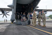 Civic leaders walk off a cargo aircraft at Duke Field flight line.