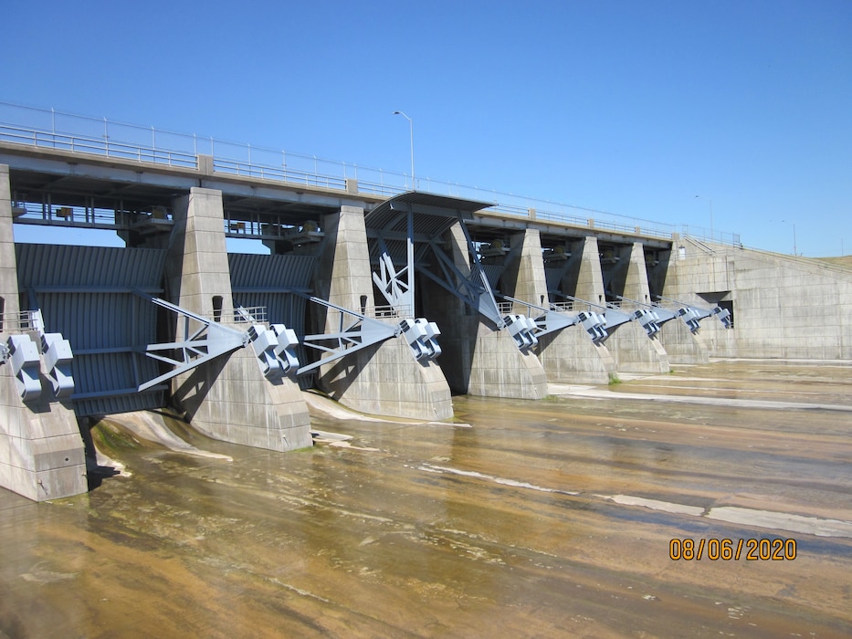 water slowly flows through the spillway gates at Big Bend Dam
