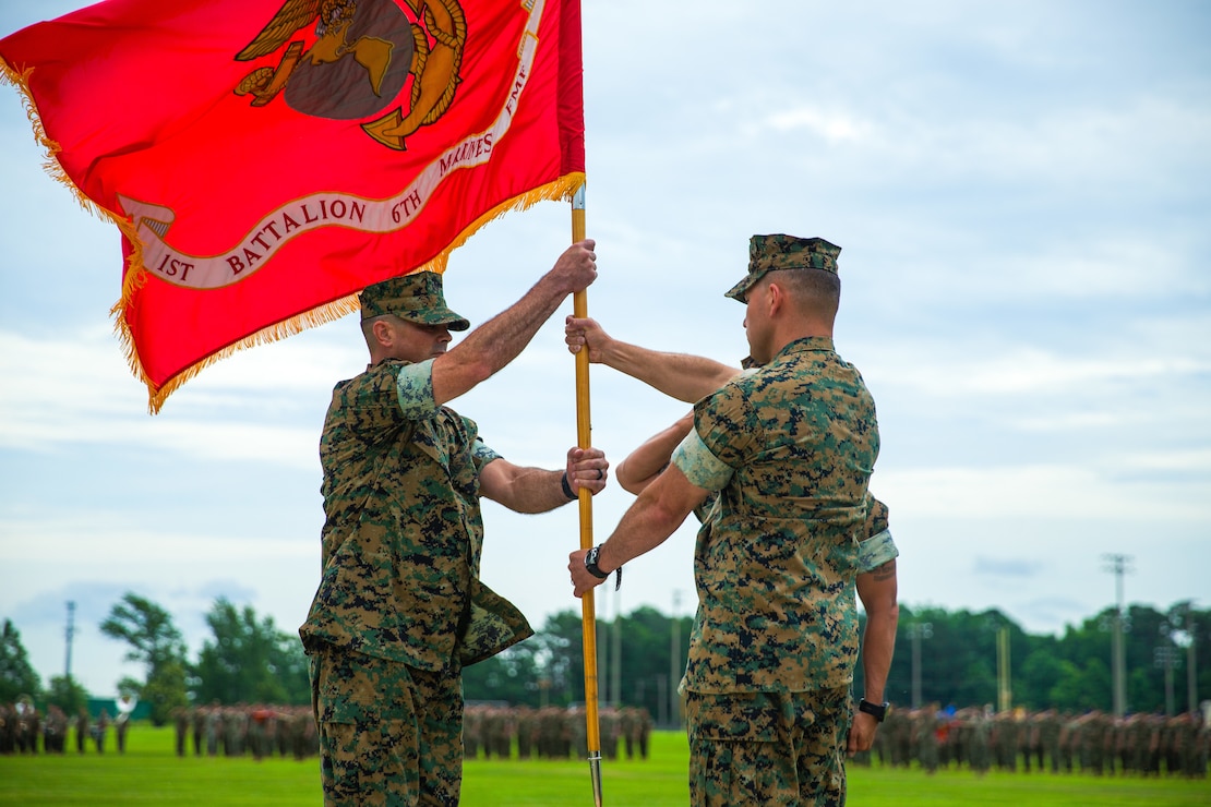 U.S. Marine Corps Lt. Col. Mastin M. Robeson, right, the outgoing battalion commander of 1st Battalion, 6th Marine Regiment, 2d Marine Division, transfers the guidon to Lt. Col. Scott H. Helminski during a change of command ceremony on Camp Lejeune, North Carolina, June 9, 2022. The transfer of the color signifies the transfer of authority and responsibility of the unit. (U.S. Marine Corps photos by Lance Cpl. Justin Brown)