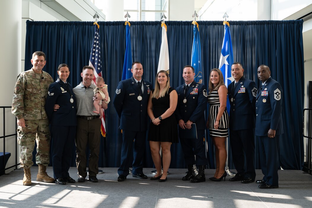 U.S. Air Force Lt. Gen. Michael A. Loh, left, director, Air National Guard (ANG), and Chief Master Sgt. Maurice L. Williams, right, command chief, ANG, pose for a photo with the 2022 Outstanding Airmen of the Year (OAY) honorees and their families during the OAY ceremony at Joint Base Andrews, Maryland, on Aug. 25, 2022.