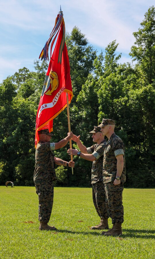 U.S. Marine Corps Lt. Col. Scott Cuomo, right, the outgoing battalion commander of 2d Light Armored Reconnaissance Battalion (LAR), 2d Marine Division, receives the colors from Sgt. Maj. Rusty Stowers, the battalion sergeant major of 2d LAR, at a change of command ceremony on Camp Lejeune, North Carolina, June 15, 2022.