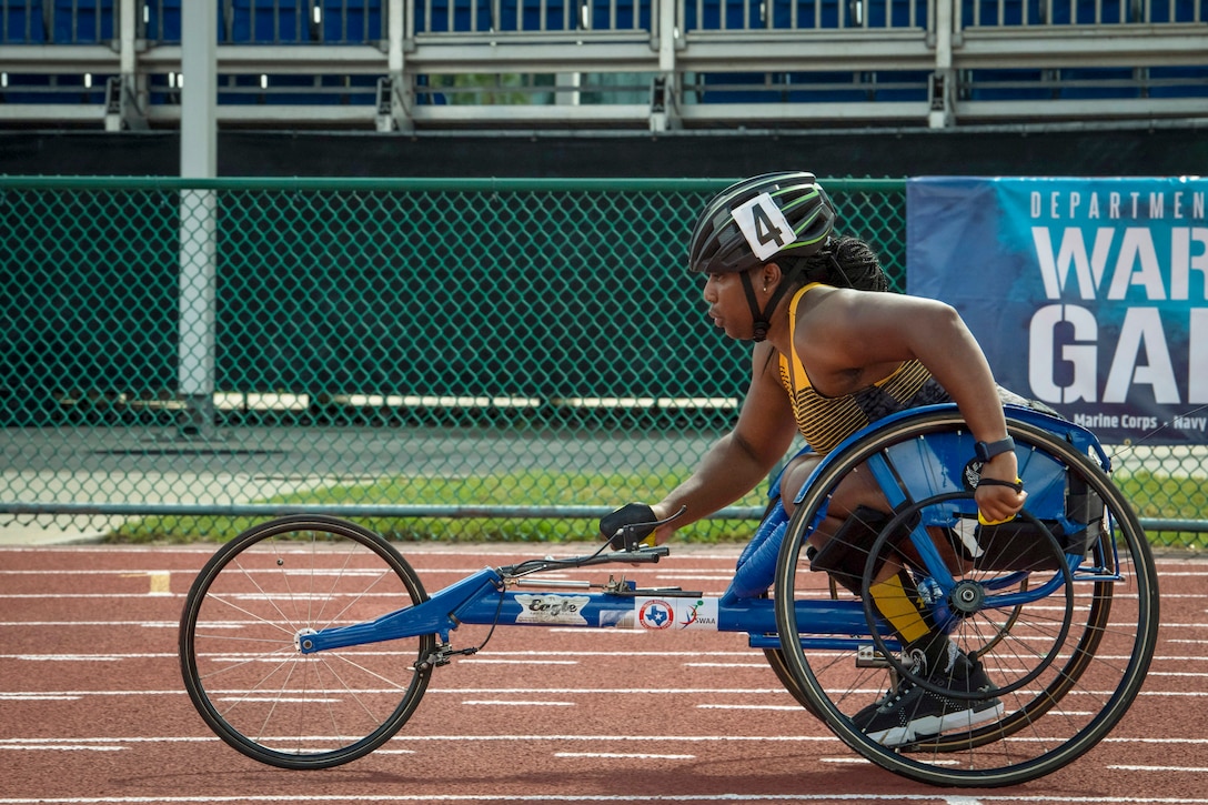 An athlete uses a low, three-wheeled bike on a track.