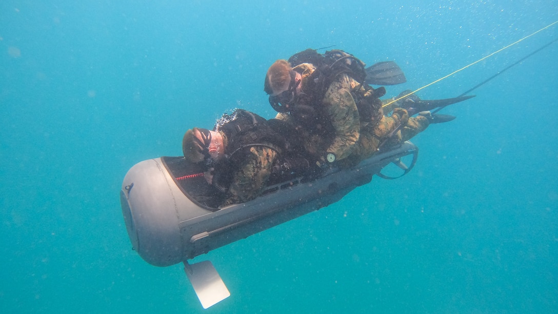U.S. Marines with 2d Reconnaissance Battalion, 2d Marine Division, operate a diver propulsion device during Exercise Caribbean Coastal Warrior in Savaneta, Aruba, June 17, 2022. This bilateral training exercise allows 2d Recon to expand its knowledge and proficiency when operating in littoral and coastal regions. Caribbean Coastal Warrior continues to increase global interoperability between the U.S. Marines and Marine Squadron Carib, Netherlands Marine Corps, as well as Caribbean Urban Warrior, an annual training evolution conducted on Camp Lejeune, North Carolina. (U.S. Marine Corps photo by Lance Cpl. Ryan Ramsammy)