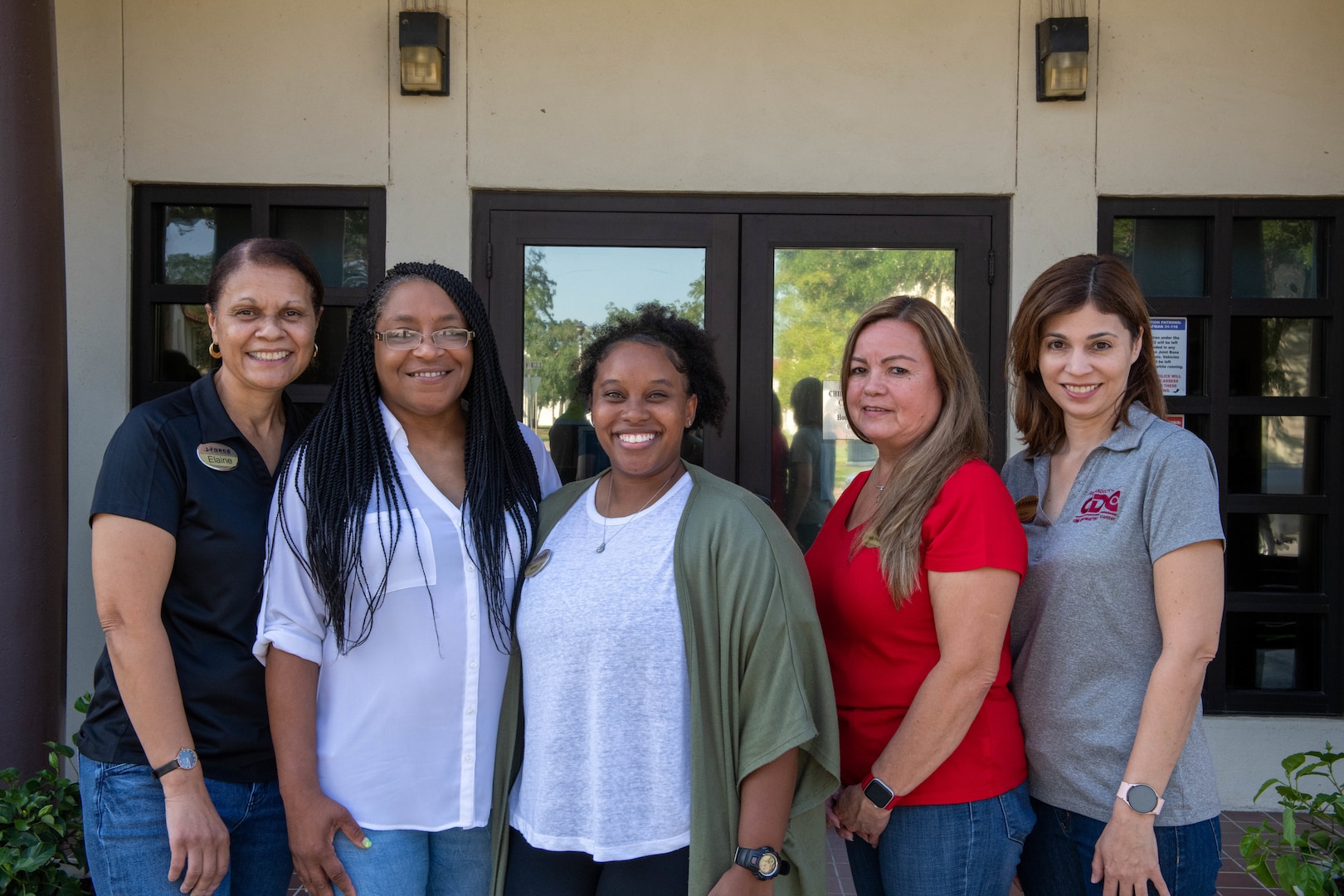 close-up photo of five women standing in front of a building