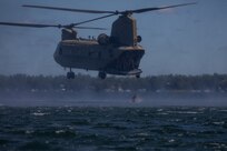 A 20th Special Forces Group (Airborne) soldier jumps out of a CH-47 Chinook assigned to 2nd Squadron, 107th Cavalry Regiment, Ohio National Guard, and hits the water of Lake Margrethe at Camp Grayling, Michigan, during a helocast exercise for soldiers supporting the unit through Northern Strike 22, August 11, 2022.