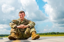 Airman 1st Class Joshua Hill, 437th Operations Support Squadron airfield management shift lead, poses for a photo on the flightline at Joint Base Charleston, South Carolina, August 19, 2022. The 437th OSS is directly responsible for airfield management, life support services, flight records management, weather and intelligence support, airlift scheduling, tactical employment and aircrew training for approximately 1,400 active and reserve personnel. (U.S. Air Force photo by Airman 1st Class Christian Silvera)