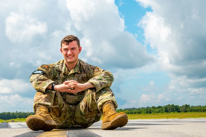 Airman 1st Class Joshua Hill, 437th Operations Support Squadron airfield management shift lead, poses for a photo on the flightline at Joint Base Charleston, South Carolina, August 19, 2022. The 437th OSS is directly responsible for airfield management, life support services, flight records management, weather and intelligence support, airlift scheduling, tactical employment and aircrew training for approximately 1,400 active and reserve personnel. (U.S. Air Force photo by Airman 1st Class Christian Silvera)