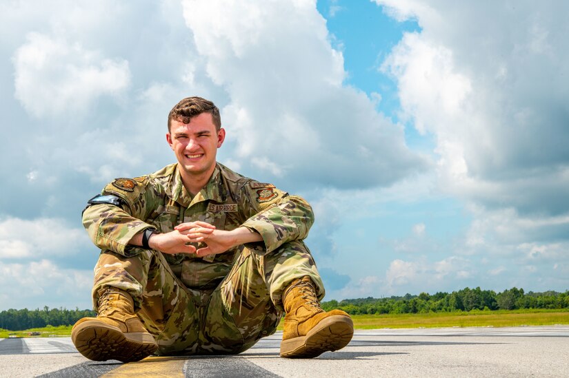 Airman 1st Class Joshua Hill, 437th Operations Support Squadron airfield management shift lead, poses for a photo on the flightline at Joint Base Charleston, South Carolina, August 19, 2022. The 437th OSS is directly responsible for airfield management, life support services, flight records management, weather and intelligence support, airlift scheduling, tactical employment and aircrew training for approximately 1,400 active and reserve personnel. (U.S. Air Force photo by Airman 1st Class Christian Silvera)