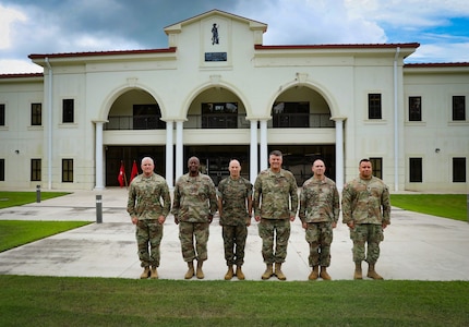 The 167th Theater Sustainment Command team poses for a picture with U.S. Marine Col. Boyd Miller outside the 167th TSC headquarters in Anniston, Alabama.