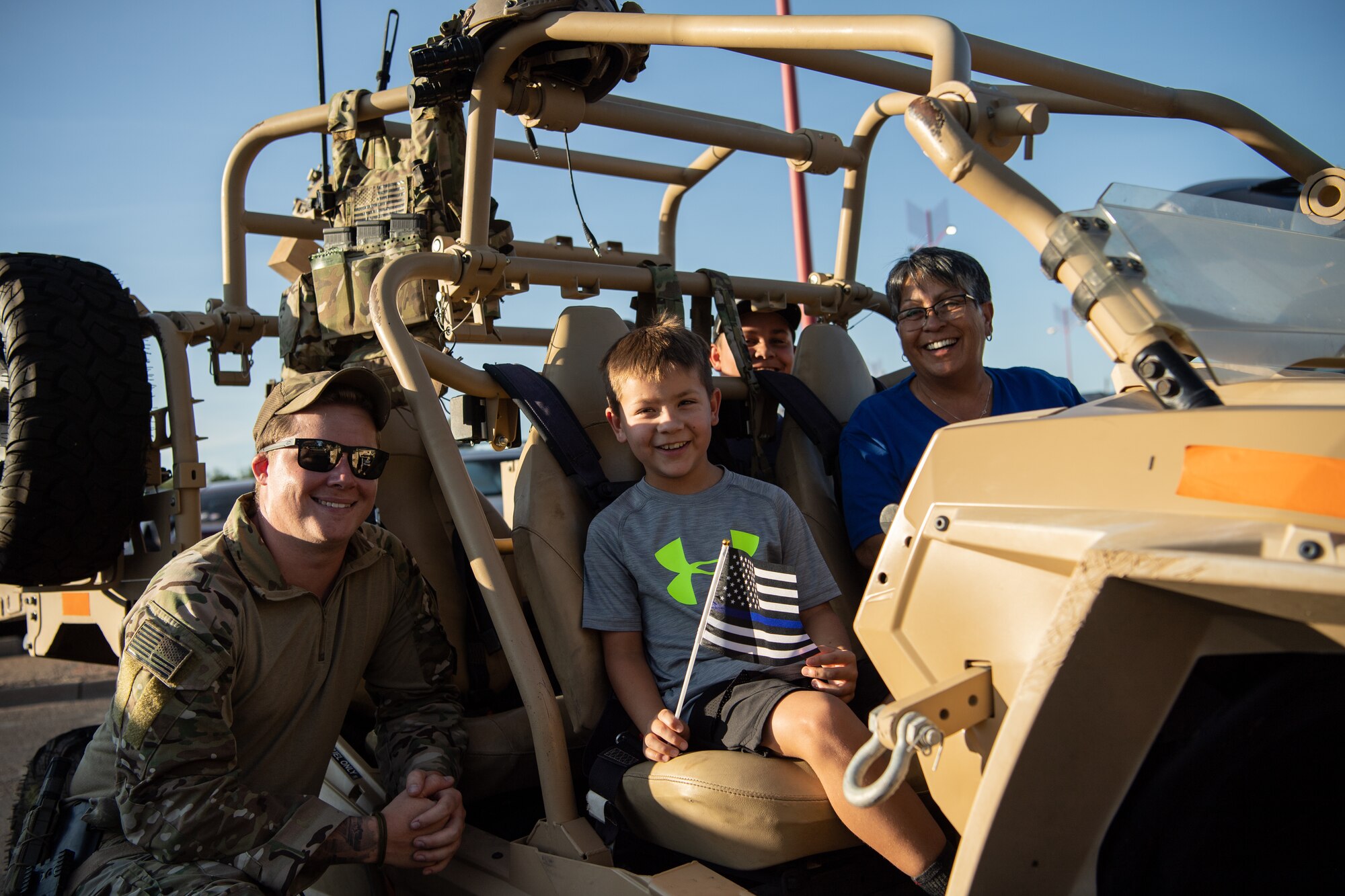 A U.S. Airman from the 27th Special Operations Wing, 27th Special Operations Security Forces Squadron, Cannon Air Force Base, showcases an MRZR all-terrain vehicle to Clovis residents during National Night Out Aug. 2, 2022, at Green Acres Park, Clovis, New Mexico. Cannon Air Commandos from the 27th SOSFS and various New Mexico law enforcement and first responders took part in the event, which is part of a nation-wide campaign to strengthen community safety and enhance relationships between residents and law enforcement. (U.S. Air Force photo by Staff Sgt. Peter Reft)