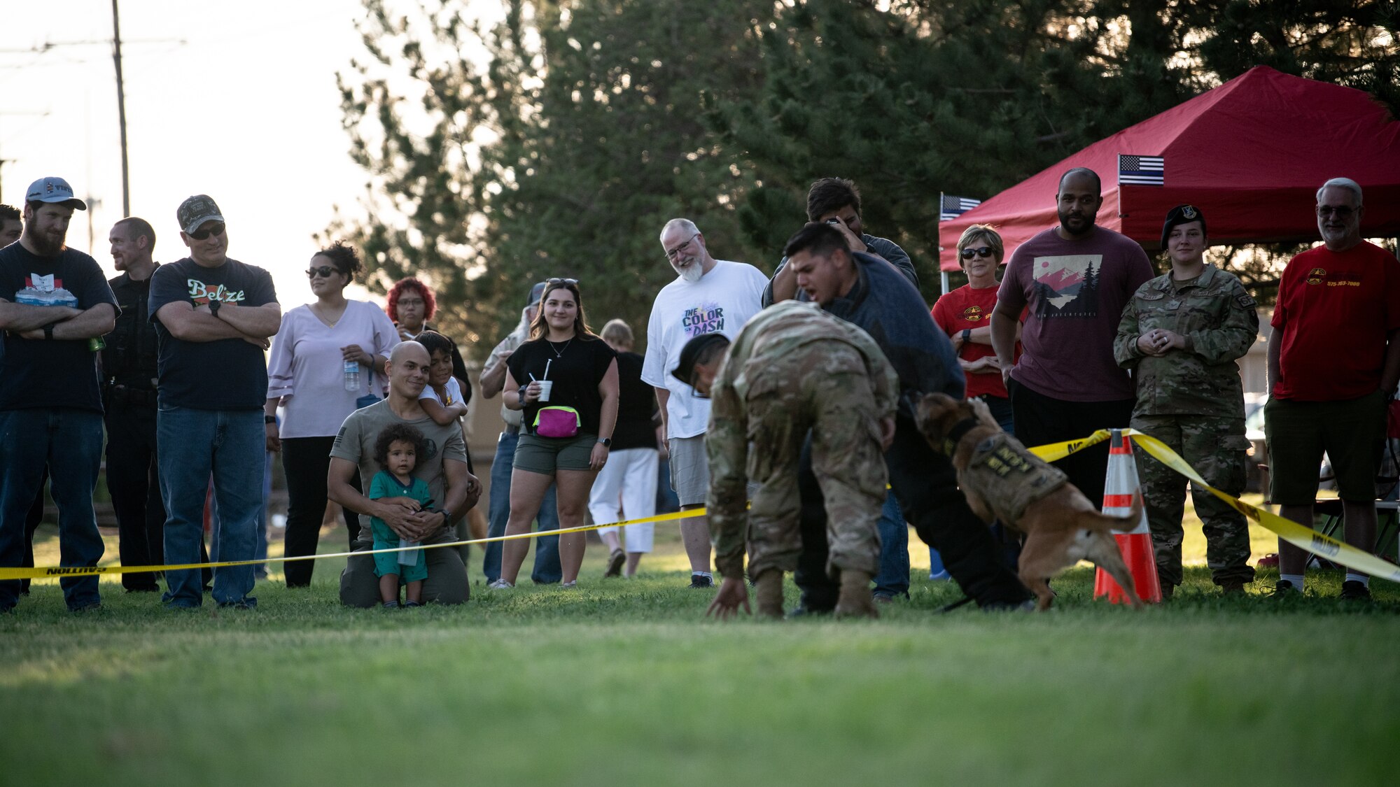 Clovis and Cannon Air Force Base families observe a military working dog demonstration during National Night Out Aug. 2, 2022, at Green Acres Park, Clovis, New Mexico. Cannon Air Commandos from the 27th SOSFS and various New Mexico law enforcement and first responders took part in the event, which is part of a nation-wide campaign to strengthen community safety and enhance relationships between residents and law enforcement. (U.S. Air Force photo by Staff Sgt. Peter Reft)
