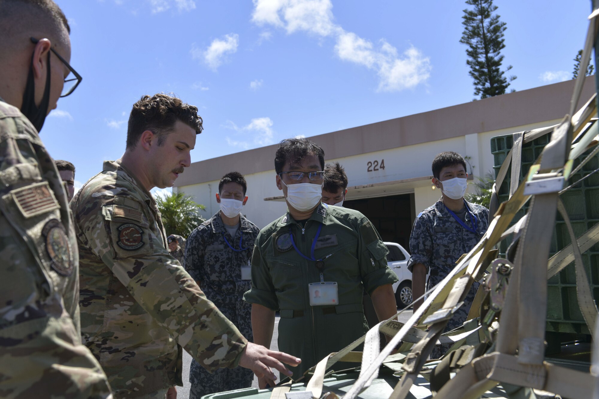 An American Airman explains packaging for planes to Japanese military members