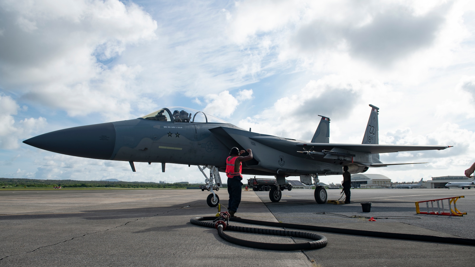 A crew chief assigned to the 44th Aircraft Maintenance Unit marshals an aircraft onto the service apron for hot-pit refueling during surge operations at Kadena Air Base, Japan, Aug. 24, 2022. Hot-pit refueling during surge operations reduces the ground time between sorties by refueling active aircraft, maximizing active training time. (U.S. Air Force photo by Senior Airman Jessi Roth)