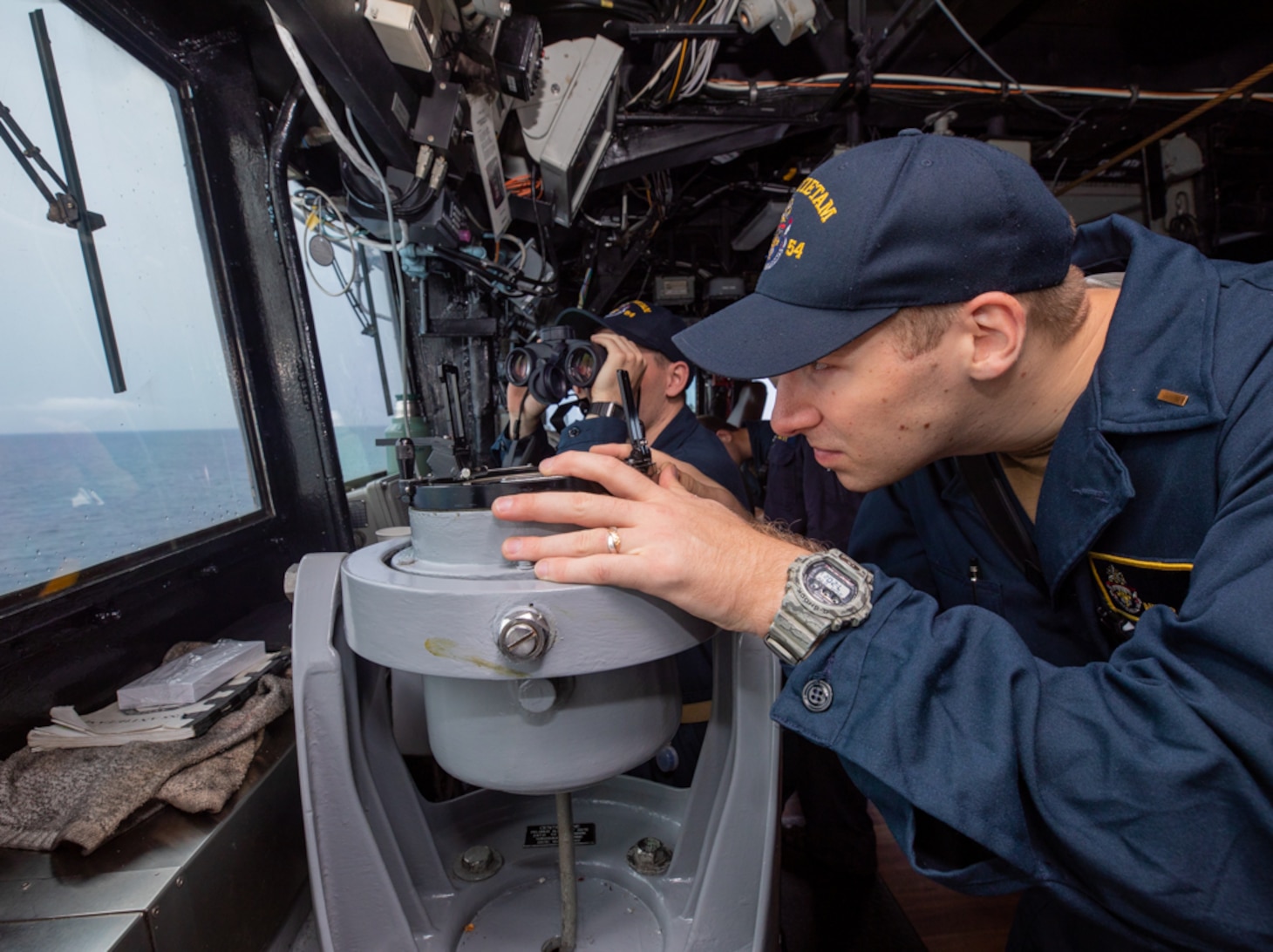 TAIWAN STRAIT (AUG 28, 2022) Ensign Minor Wetzel, from La Canada, California, right, takes ship bearing as Ensign Patrick Brady, from Dephaven, Minnesota, searches for surface contacts in the bridge as Ticonderoga-class guided-missile cruiser USS Antietam (CG 54) conducts routine Taiwan Strait Transit. Antietam is deployed to 7th Fleet area of operations in support of a free and open Indo-Pacific. (U.S. Navy photo by Mass Communication Specialist 3rd Class Santiago Navarro)