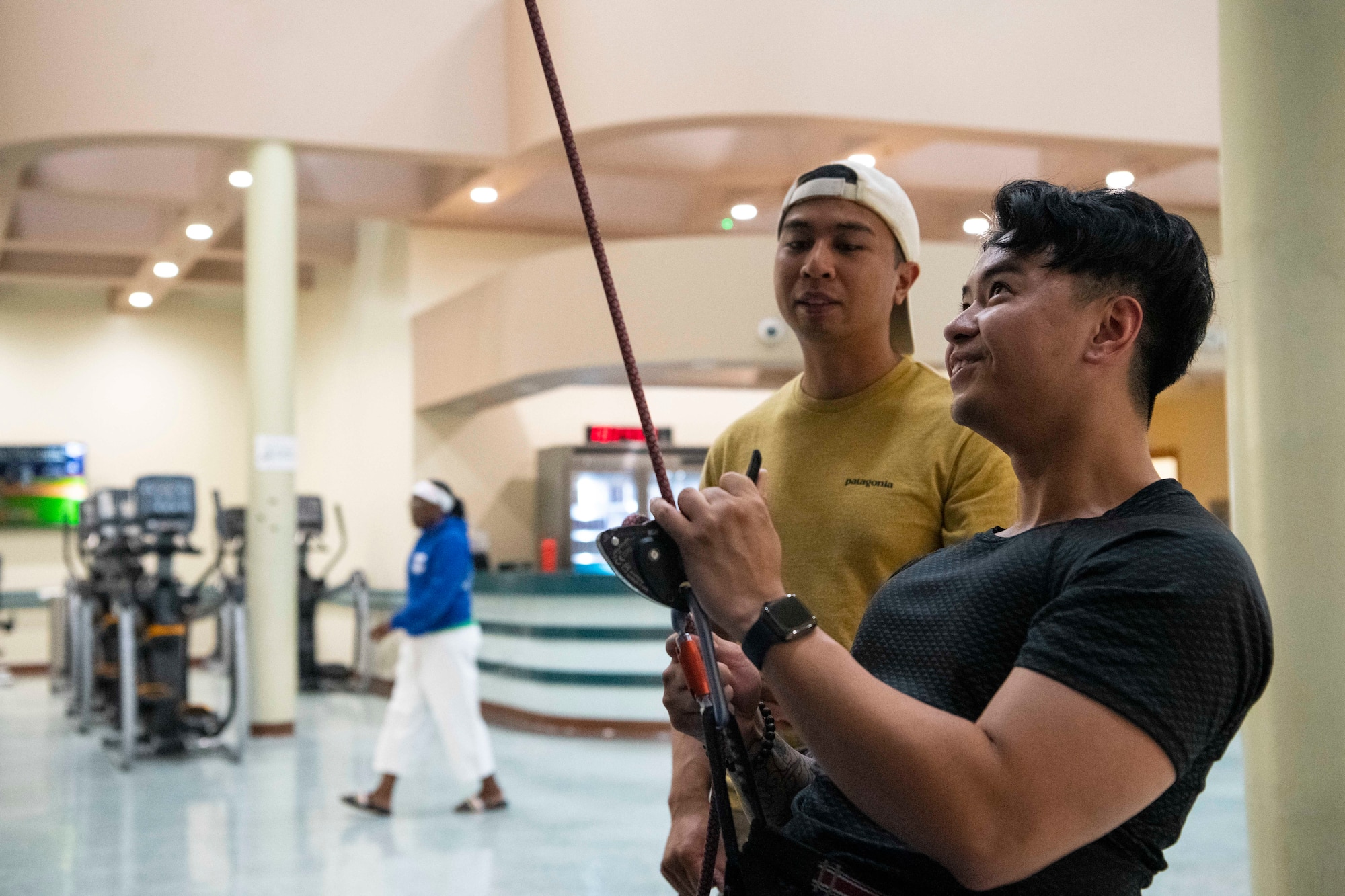 Airman 1st Class Melchor Sevillano (left), 8th Security Forces Squadron patrolman, shows Staff Sgt. Reynaldo Tamayo, 8th Medical Group systems administrator, how to belay at Kunsan Air Base, Republic of Korea, Aug. 23, 2022. Sevillano taught other Airmen proper climbing techniques to help them enjoy the activity in a safe way. (U.S. Air Force photo by Staff Sgt. Sadie Colbert)