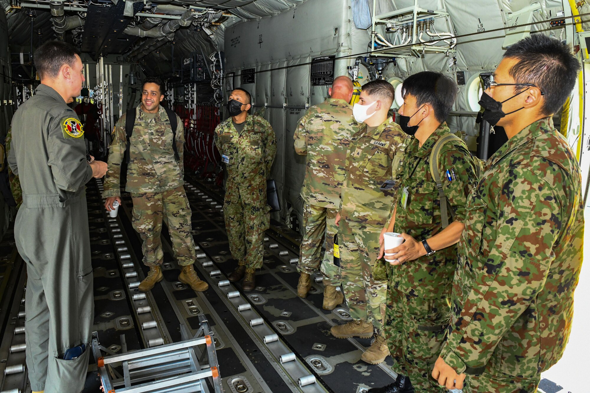 U.S. Air Force 1st Lt. Tate Tatom, 36th Airlift Squadron C-130J Super Hercules pilot, left, briefs Japan Ground Self-Defense Force members on capabilities of the C-130J at Yokota Air Base, Japan, Aug. 9, 2022. Members of the JGSDF along with U.S. Army Soldiers from Camp Zama, Japan, visited Yokota, as part of a six-week cooperative work program. This program is an opportunity for JGSDF and U.S. Army service members to improve bilateral relations, enhance language comprehension skills, learn about each others cultures and familiarize themselves with bilateral military doctrine and techniques. (U.S. Air Force photo by Tech. Sgt. Garrett Cole)