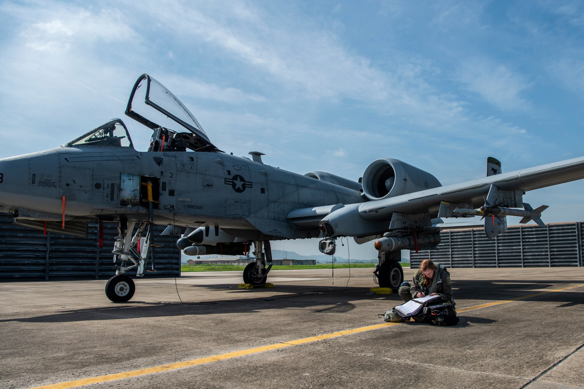 apt. Colleen Engelbrecht, 25th Fighter Squadron, pilot, fills out a post flight log in front of an A-10C Thunderbolt II after a training sortie at Gwangju Air Base, Republic of Korea, Aug. 18, 2022.