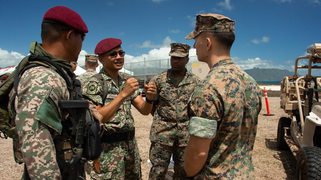 MARINE CORPS BASE HAWAII, Hawaii (Aug. 1, 2022) U.S. Marines with 3d Marine Littoral Regiment, 3d Marine Division, interact with Malaysian Army soldiers during Distinguished Visitor Day as part of the Rim of the Pacific (RIMPAC) 2022, August 1, 2022. Twenty-six nations, 38 ships, three submarines, more than 170 aircraft and 25,000 personnel are participating in RIMPAC from June 29 to Aug. 4 in and around the Hawaiian Islands and Southern California. The world's largest international maritime exercise, RIMPAC provides a unique training opportunity while fostering and sustaining cooperative relationships among participants critical to ensuring the safety of sea lanes and security on the world's oceans. RIMPAC 2022 is the 28th exercise in the series that began in 1971. (U.S. Marine Corps photo by Sgt. Melanye Martinez)