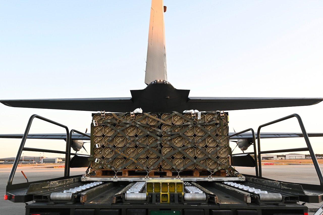 Pallets of ammunition are loaded onto an aircraft.
