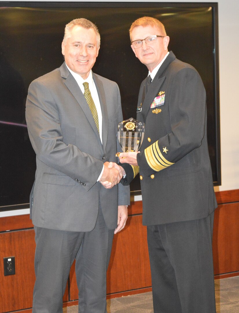 IMAGE: Principal Strategic Weapons System Engineer and Principal Scientist Robert “Chris” Scranton shakes hands with Vice Adm. Johnny Wolfe, who presented Scranton with the Navy’s Strategic Systems Programs Director’s Award during an awards ceremony held May 12 at the Washington Navy Yard.