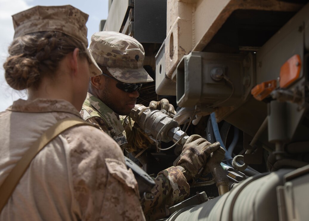 U.S. Marine Corps Lance Cpl. Jacquelyn Rosa, left, a motor transport operator with Combat Logistics Regiment 1, 1st Marine logistics Group, and U.S. Army Spc. Jonathan Pleasant, a petroleum supply specialist with 252nd Quartermaster Company, refuel a tactical vehicle after the completion of the first leg of a convoy at a combat support center established in Kingdom of Saudi Arabia during exercise Native Fury 22, Aug. 14, 2022. Native Fury 22 is vital for strengthening the U.S. long-standing relationship with Saudi Armed Forces. The exercise enhances combined tactics, maritime capabilities and promotes long-term regional stability. (U.S. Marine Corps photo by Cpl. Casandra Lamas)