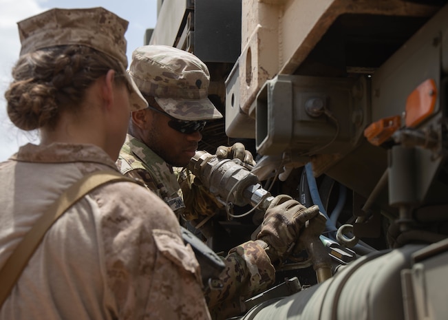U.S. Marine Corps Lance Cpl. Jacquelyn Rosa, left, a motor transport operator with Combat Logistics Regiment 1, 1st Marine logistics Group, and U.S. Army Spc. Jonathan Pleasant, a petroleum supply specialist with 252nd Quartermaster Company, refuel a tactical vehicle after the completion of the first leg of a convoy at a combat support center established in Kingdom of Saudi Arabia during exercise Native Fury 22, Aug. 14, 2022. Native Fury 22 is vital for strengthening the U.S. long-standing relationship with Saudi Armed Forces. The exercise enhances combined tactics, maritime capabilities and promotes long-term regional stability. (U.S. Marine Corps photo by Cpl. Casandra Lamas)