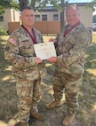 Lt. Col. Chris Gookin receives an Order of Military Medical Merit award from Col. George Horsley, Massachusetts Army National Guard state surgeon, at Camp Johnson, Vermont, on Aug. 4, 2022. Gookin was cited for his accomplishments in establishing 98 percent medical readiness for the Vermont Army National Guard and for his work with state partners Senegal and North Macedonia. (courtesy photo)