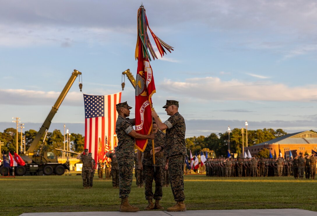 U.S. Marine Corps Maj. Gen. Francis Donovan, right, the outgoing commanding general (CG) of 2d Marine Division (MARDIV), passes the division colors to Brig. Gen. Calvert Worth, the incoming CG of 2d MARDIV, at a change of command ceremony on Camp Lejeune, North Carolina, Aug. 18, 2022.